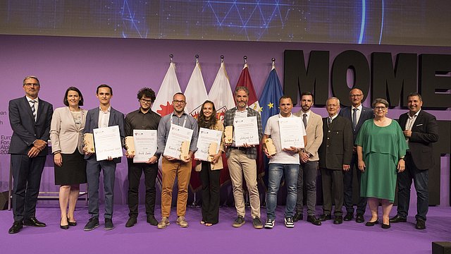 I vincitori del Premio Euregio per i Giovani Ricercatori e del Premio Euregio Innovazione (con i relativi attestati, da sinistra a destra): il Presidente dell'Euregio e Presidente della Provincia Autonoma di Bolzano Arno Kompatscher, Barbara Thaler (Presidente della Camera di Commercio del Tirolo), Sebastian Holzer (2° classificato - Premio  Innovazione), Ariele Zanfei (1° classificato - Premio Giovani Ricercatori), Roberto Andreotti (2° classificato - Premio Giovani Ricercatori), Nadja Gruber (3° classificato - Premio Giovani Ricercatori), Matteo Dall'Amico (1° classificato - Premio Innovazione), Stefano Martini (3° classificato - Premio Innovazione), insieme all'Assessore della Provincia Autonoma di Trento  Simone Marchiori, Michl Ebner (Presidente della Camera di Commercio di Bolzano), il Capitano del Tirolo Anton Mattle, Ulrike Tappeiner (Presidente della giuria del Premio Giovani Ricercatori nonché Presidente della Libera Università di Bolzano) e Markus Hofer (Presidente della giuria del Premio Innovazione).