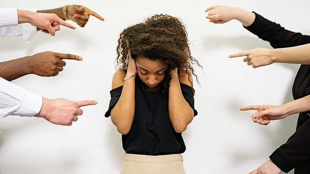 © pexels/Yan Krukau Viele Menschen, die auf eine Frau zeigen, als Zeichen der Diskriminierung