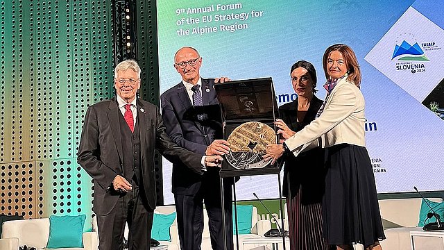 Die Übergabe des symbolischen „Kolo Wheel“. v.li.: LH Peter Kaiser (Kärnten), LH Anton Mattle, Dominique Hasler, Außenministerin und stellvertretende Ministerpräsidentin Liechtensteins und Tanja Fajon, stellvertretende Ministerpräsidentin und Außenministerin Sloweniens.