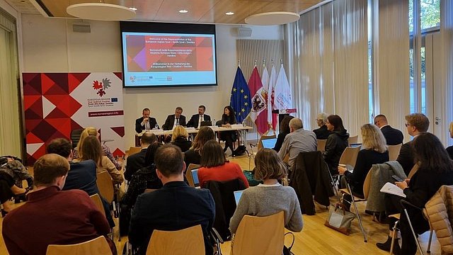 Podiumsgäste im vollbesetzten Saal bei der Veranstaltung „Regional- und Minderheitensprachenunterricht im vorwissenschaftlichen Zeitalter“.