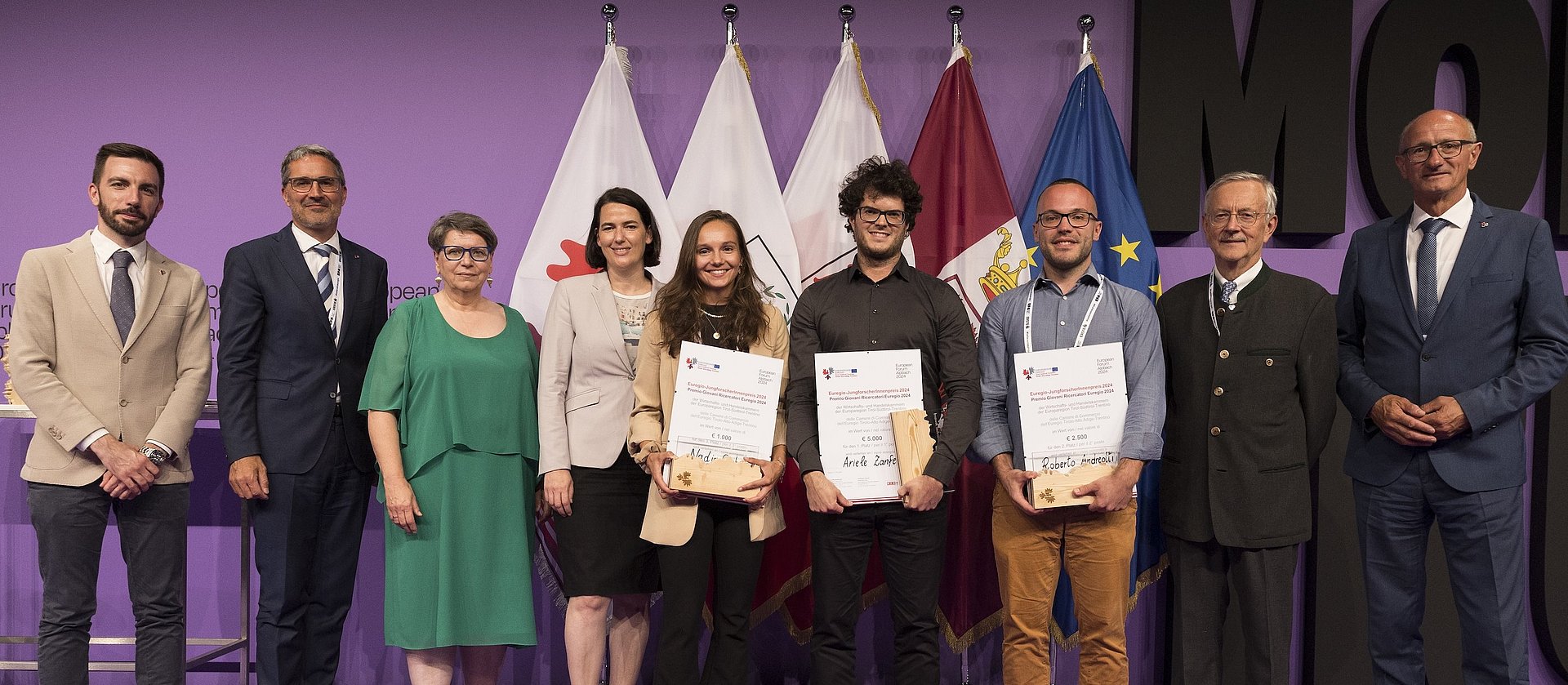 Gewinner:innen des Euregio-JungforscherInnenpreises 2024: v.l. Simone Marchiori (Landesrat des Trentino), Arno Kompatscher (Euregio-Präsident und Landeshauptmann von Südtirol), Ulrike Tappeiner (Jury-Vorsitzende und Präsidentin der Freien Universität Bozen), Barbara Thaler (Präsidentin der Wirtschaftskammer Tirol), Nadja Gruber (3. Platz), Ariele Zanfei (1. Platz), Roberto Andreotti (2. Platz), Michl Ebner (Präsident der Handelskammer Bozen und Anton Mattle (Landeshauptmann von Tirol.