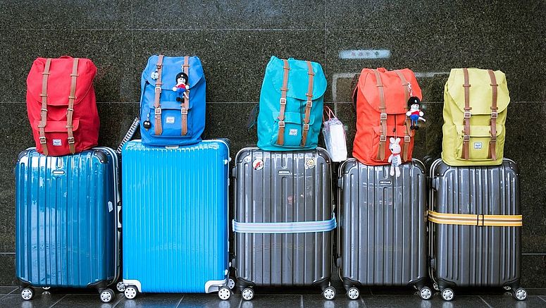 Gepackte Koffer und Rucksäcke stehen an der Wand.