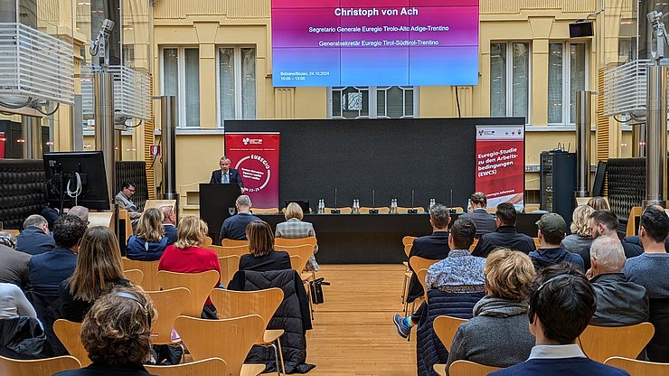 Euregio-Generalsekretär Christoph von Ach begrüßt die Teilnehmer:innen der Tagung zur Vorstellung der neuen EWCS-Studie zu Karriere und Weiterbildung im Spiegelsaal des Palais Widmann in Bozen