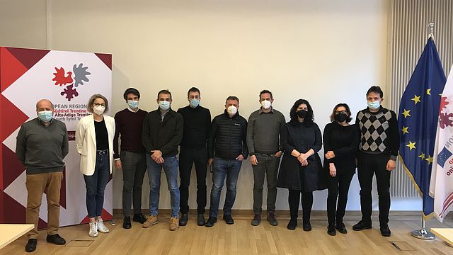 Delegazione di 10 sindaci trentini nella sala delle conferenze, accanto alle bandiere e al logo della Rappresentanza comune di Bruxelles.