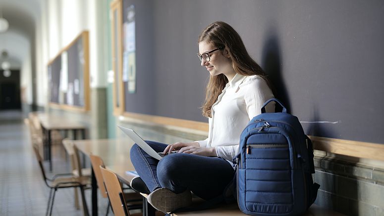 Donna seduta alla finestra con un computer portatile.